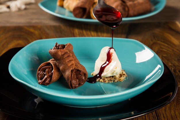 Cannoli con gelato, cioccolato e mandorle nel piatto