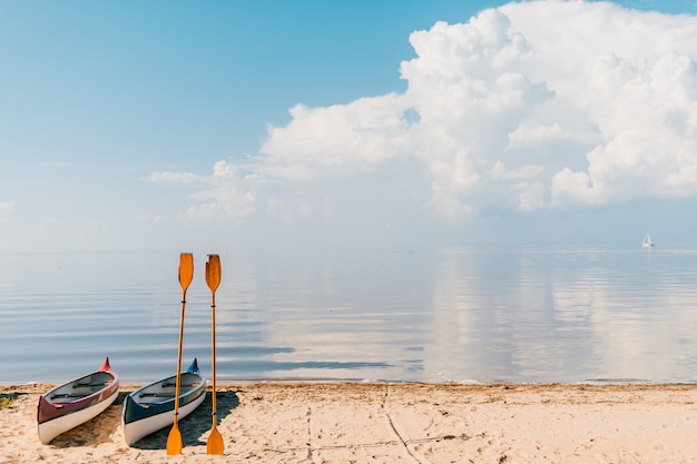 Canoa sulla spiaggia nel giorno di estate soleggiato sul mare vago con le nuvole
