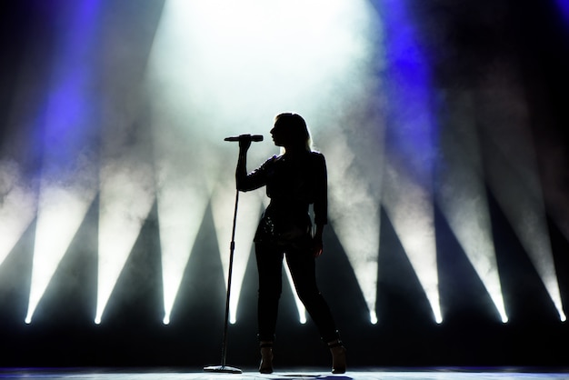 Cantante che canta al microfono. Cantante in silhouette