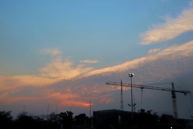 Cantiere che si staglia contro il cielo colorato di sera con cielo blu e nuvole. Industriale.