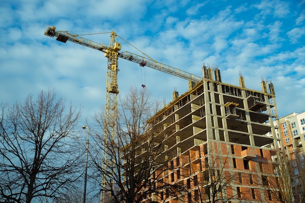 Cantiere con gru cielo blu con nuvole bianche su sfondo