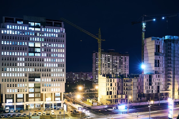 Cantiere con gru su sfondo scuro del cielo di notte