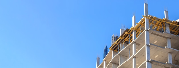 Cantiere residenziale dell'insegna contro il fondo del cielo blu con lo spazio della copia. Foto di concetto di industria delle costruzioni