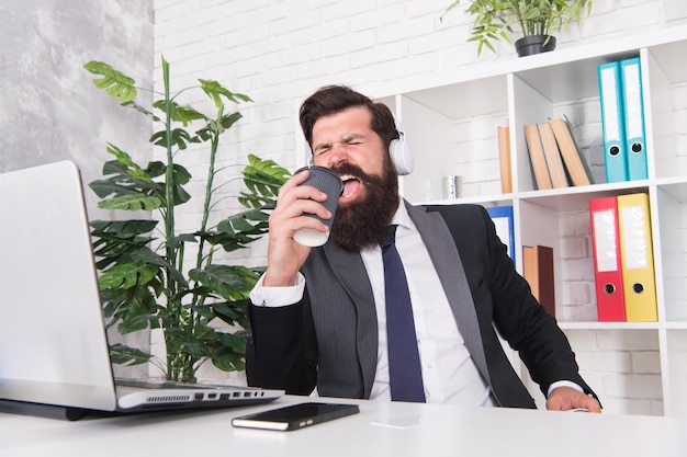 Canto uomo d'affari. L'uomo d'affari canta una canzone sul posto di lavoro. Tazza di caffè della tenuta dell'uomo d'affari come microfono. L'uomo d'affari barbuto si diverte durante la pausa di lavoro. Musica. Divertimento. Rilassamento.