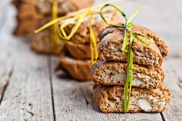 Cantuccini di biscotti italiani fatti in casa freschi con semi di mandorle sul tavolo in legno ructic