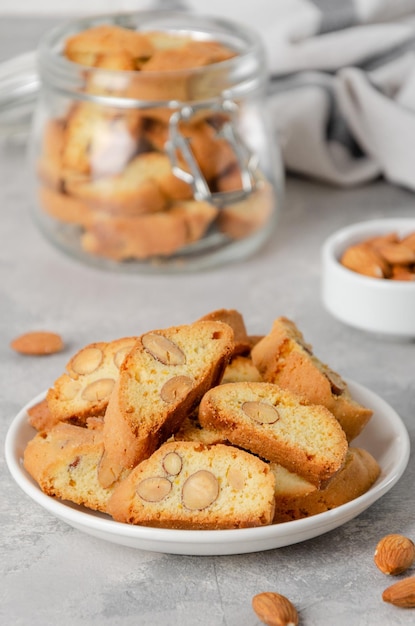 Cantuccini italiani tradizionali con mandorle su un piatto su uno sfondo di cemento grigio