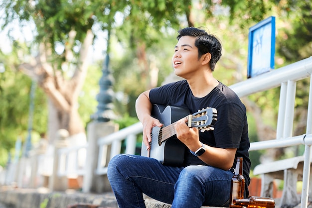 Canzone di canto dell'adolescente e suonare la chitarra