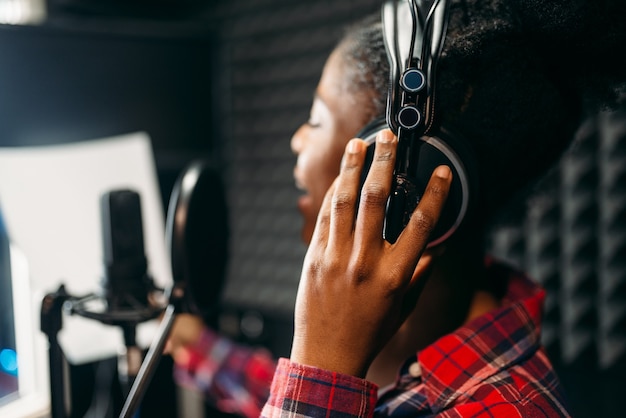 Canzoni della giovane donna in studio di registrazione audio