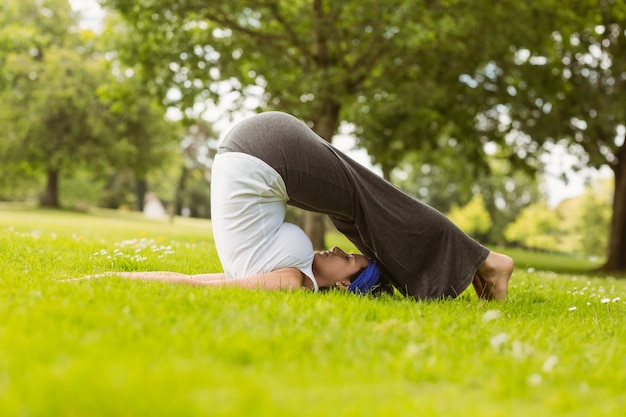 Capelli castani facendo yoga sull&#39;erba