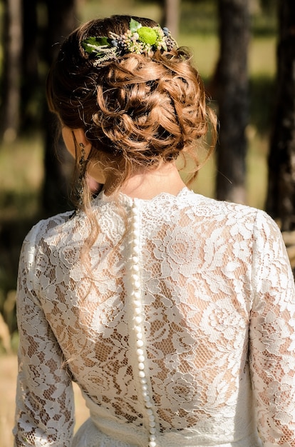 Capelli della sposa indietro, riccioli intrecciati con fiori