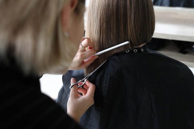 Capelli di taglio del parrucchiere nel primo piano del salone