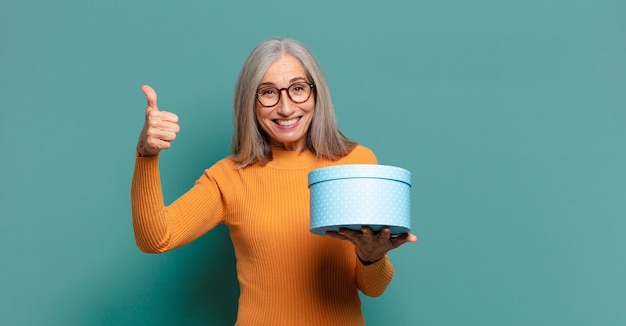 Capelli grigi Bella donna con una confezione regalo