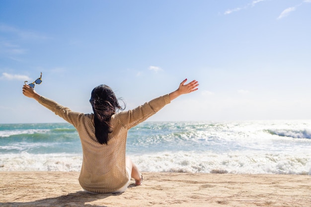 Capelli lunghi donna asiatica seduta rilassante sulla spiaggia