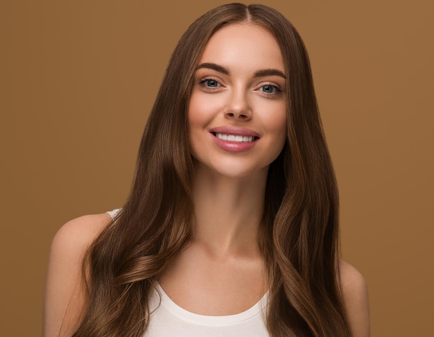 Capelli lunghi sani donna con capelli ricci lunghi bellezza pelle viso ritratto. Colore di sfondo marrone