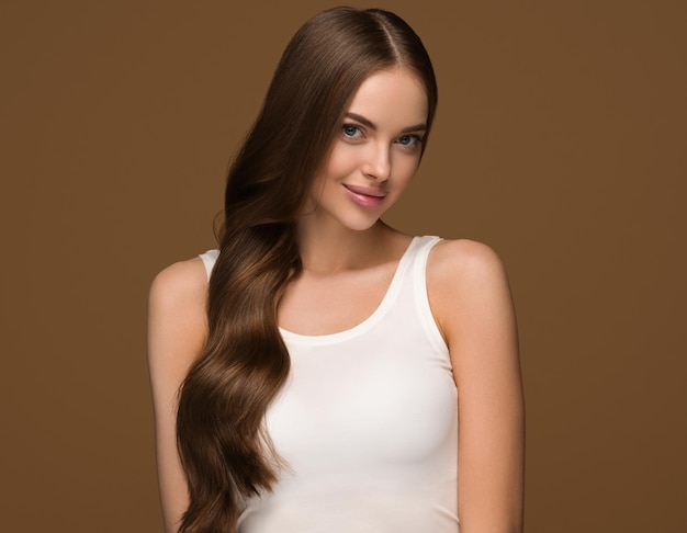 Capelli lunghi sani donna con capelli ricci lunghi bellezza pelle viso ritratto. Colore di sfondo marrone