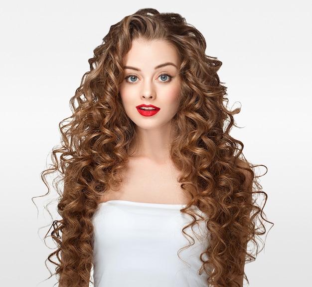 Capelli ricci ritratto di donna capelli lunghi con trucco perfetto labbra rosse isolate su bianco