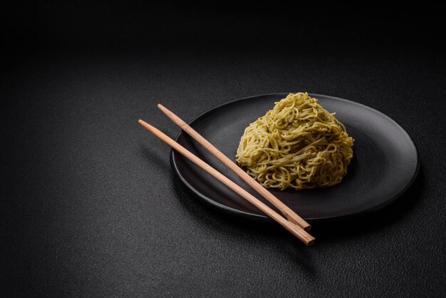 Capellini o tagliatelle con pesto sale e spezie su fondo di cemento scuro