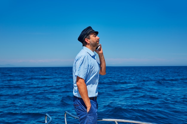 Capitano cappuccio marinaio uomo parlando barca del telefono mobile