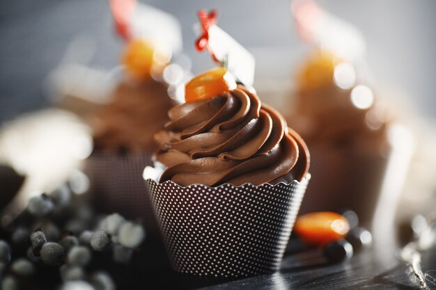 Capkake al cioccolato su tela decorata con kumquat e mirtilli