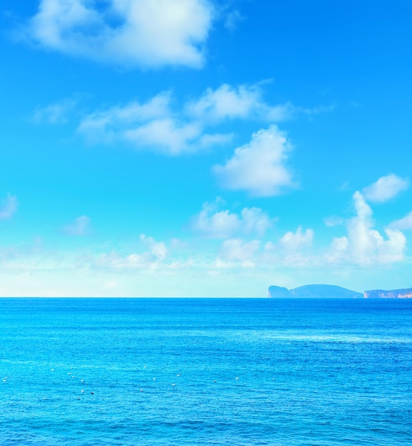 Capo Caccia sotto un cielo azzurro con nuvole Sardegna