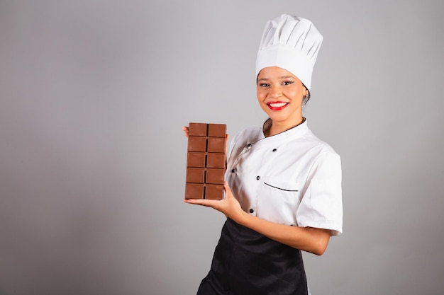 Capo chef Cuoco brasiliano del nord-est che tiene in mano una tavoletta di cioccolato specialista nella preparazione della Pasqua al cioccolato