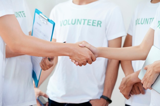 Capo dei volontari con appunti che stringono la mano del nuovo membro dell'organizzazione