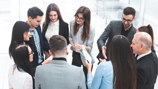 Capo e un gruppo di dipendenti che discutono di documenti aziendali. il concetto di lavoro di squadra