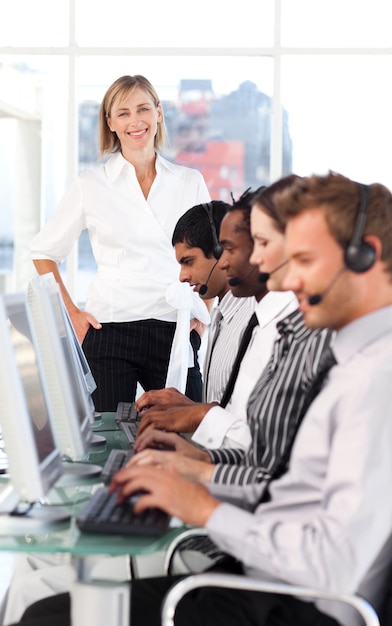 Capo femminile allegro con una squadra su un call center