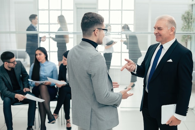 Capo serio che spiega qualcosa al suo assistente. giorni lavorativi in ufficio