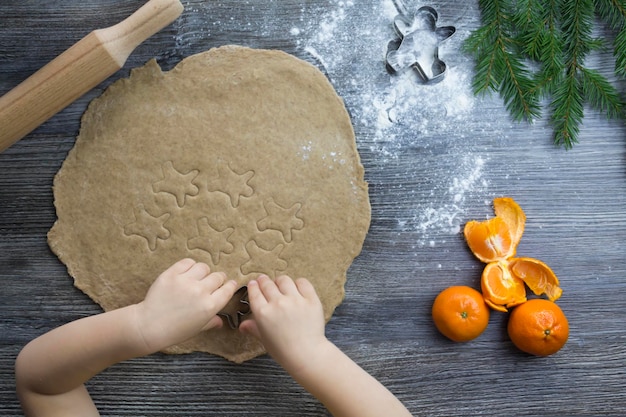 Capodanno e decorazioni natalizie su una superficie di legno con mandarini e un albero di natale la mano