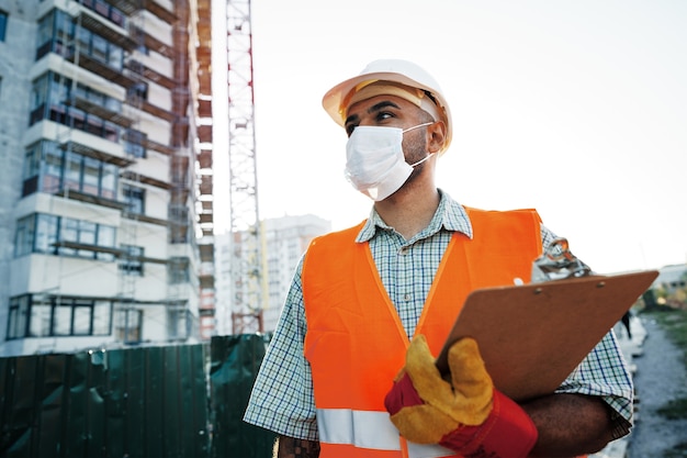 Caposquadra al lavoro in cantiere controllando le sue note negli appunti