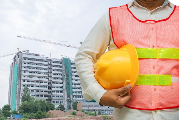 Caposquadra asiatico con edificio in costruzione sfondo