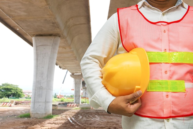 Caposquadra asiatico con ponte sfocato in costruzione sullo sfondo