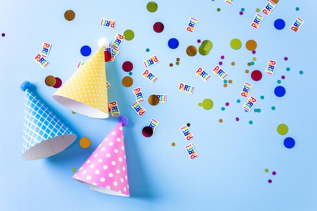 Cappelli colorati per feste di compleanno per bambini su sfondo blu.