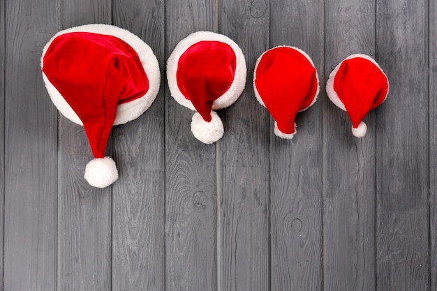 Cappelli di Babbo Natale di Natale per la famiglia su fondo in legno