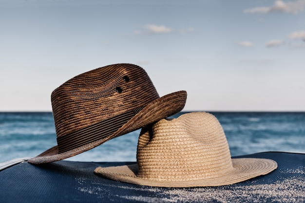 Cappelli Estivi Sulla Sedia In Spiaggia Con Il Mare Come Sfondo