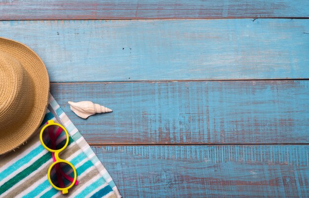 Cappelli, occhiali da sole, scarpe da spiaggia, asciugamani sul tavolo