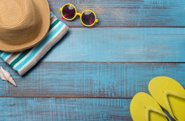 Cappelli, occhiali da sole, scarpe da spiaggia, asciugamani sul tavolo