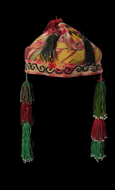 Cappello a zucchetto asiatico tradizionale colorato con trecce su sfondo scuro