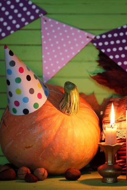 Cappello con candela natalizia zucca sul tavolo