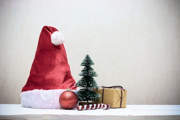 Cappello da Babbo Natale con decorazioni natalizie su tavola di legno