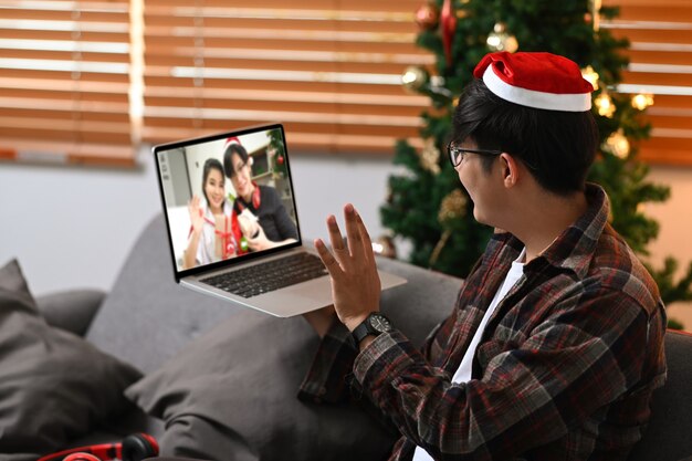 Cappello da Babbo Natale rosso con videochiamata per celebrare le vacanze con la sua famiglia.