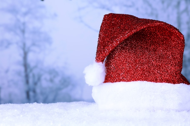 Cappello da Babbo Natale sulla neve su sfondo invernale