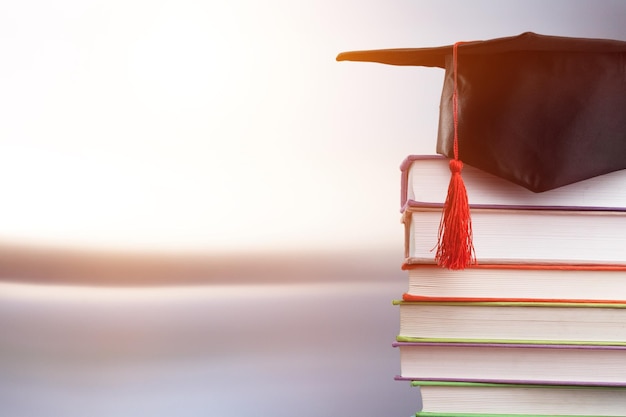 Cappello da studente di laurea con libri universitari.