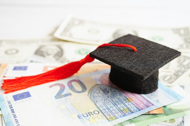 Cappello del divario di laurea su banconote in euro e dollari USA