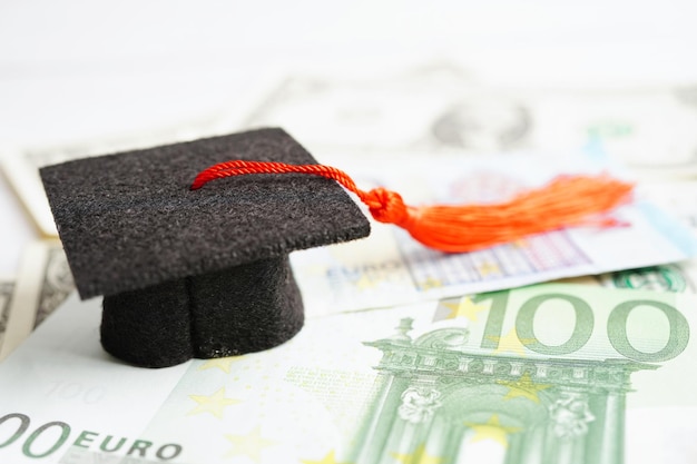 Cappello del divario di laurea su banconote in euro e dollari USA