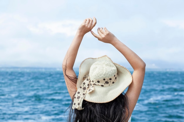 Cappello della testa della donna nella priorità bassa del mare