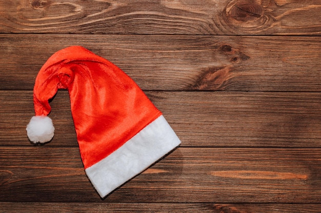 Cappello di Babbo Natale in velluto rosso su sfondo di legno