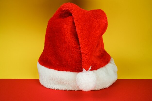 Cappello di Babbo Natale rosso su sfondo colorato. Cartolina di Natale concetto. Foto di alta qualità