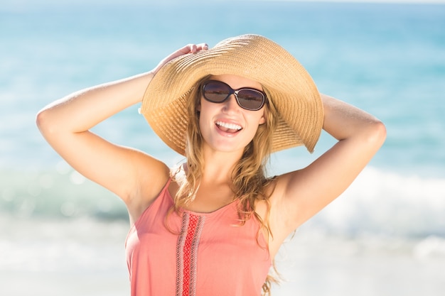 Cappello di paglia d&#39;uso della bionda graziosa ed esaminare macchina fotografica